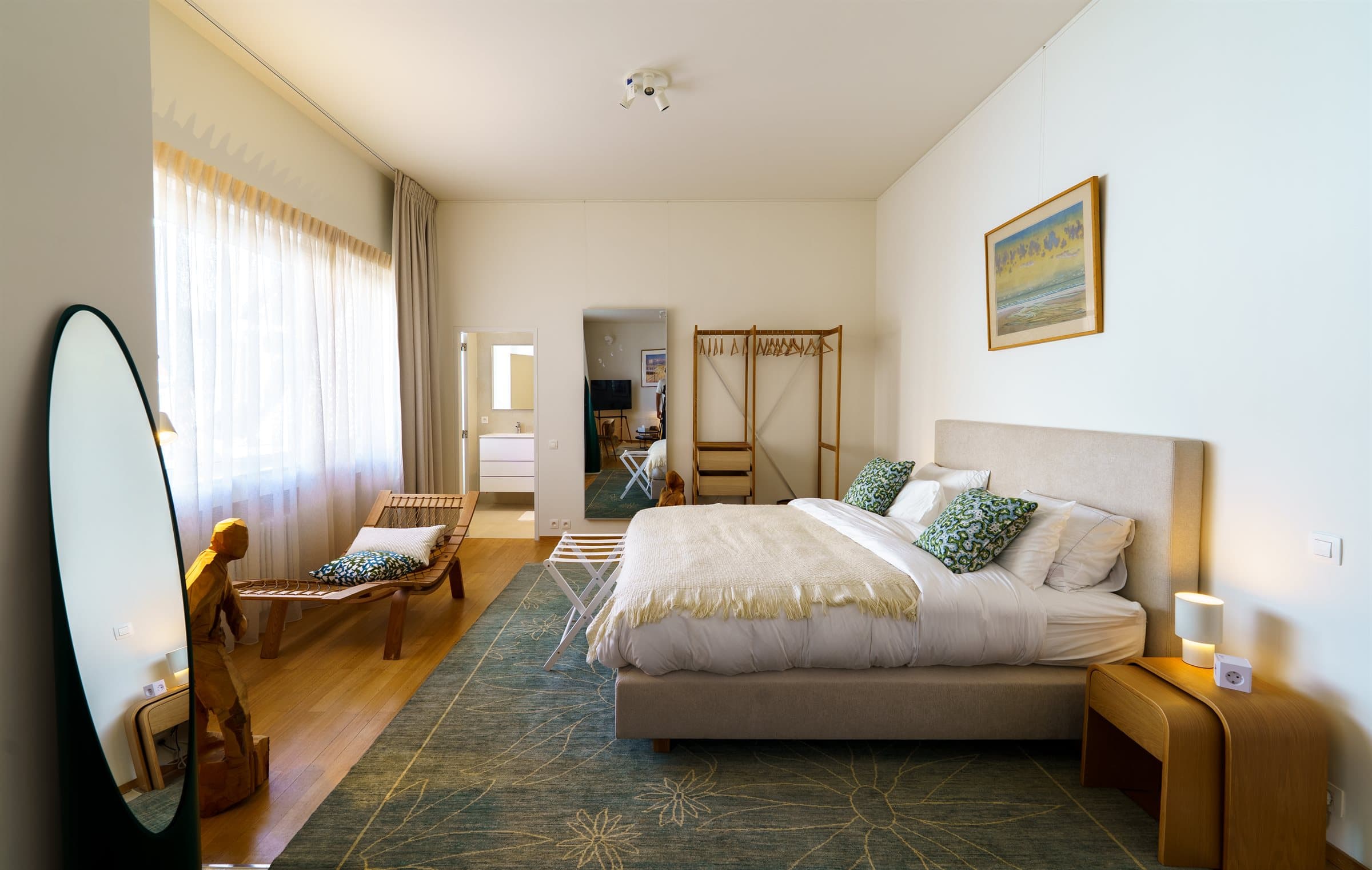 Second-floor en-suite bedroom with a reading chaise and a teal patterned rug
