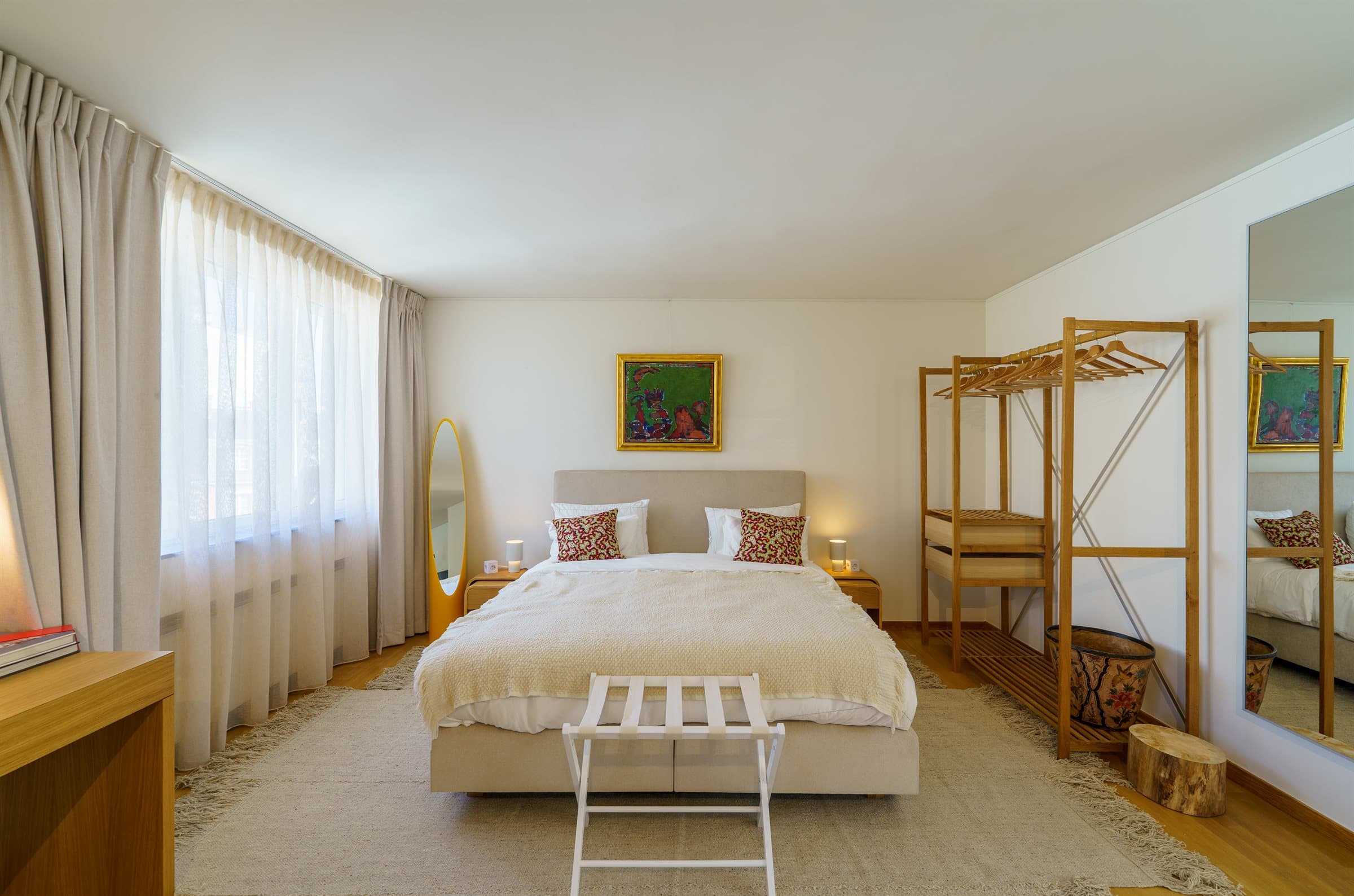 Top-floor en-suite bedroom with original art and a jute rug