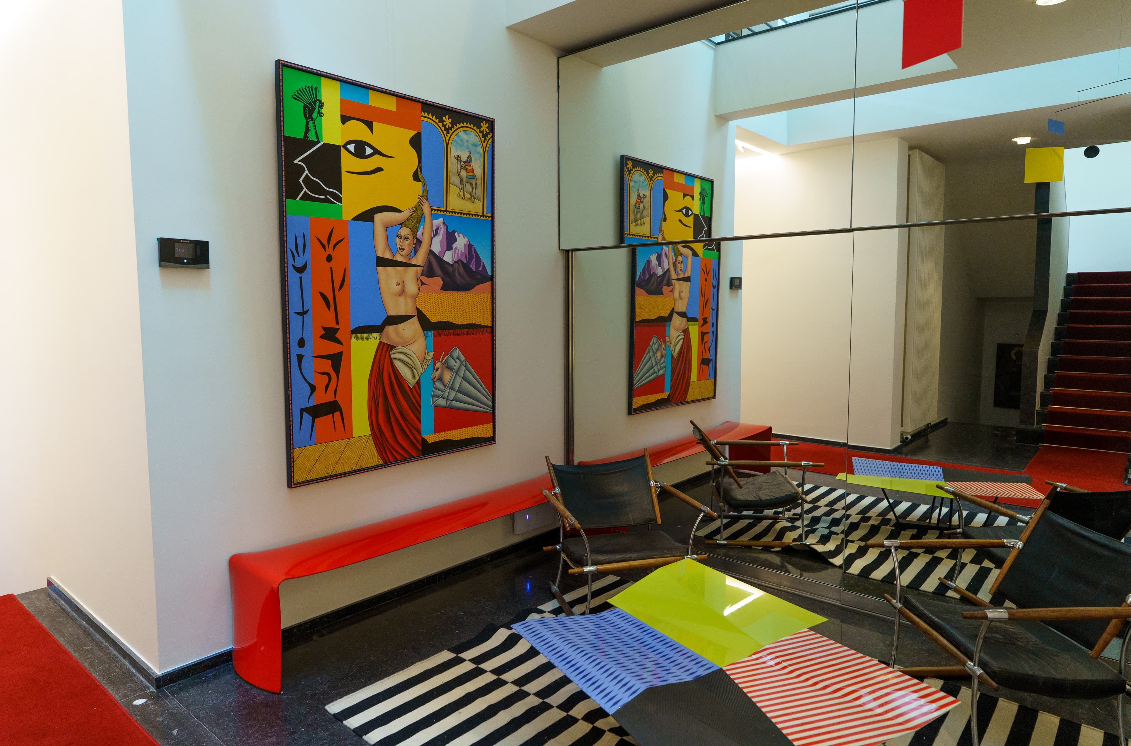 Entrance hall with a bold artwork and a red bench at Maison Lemonnier, Uccle