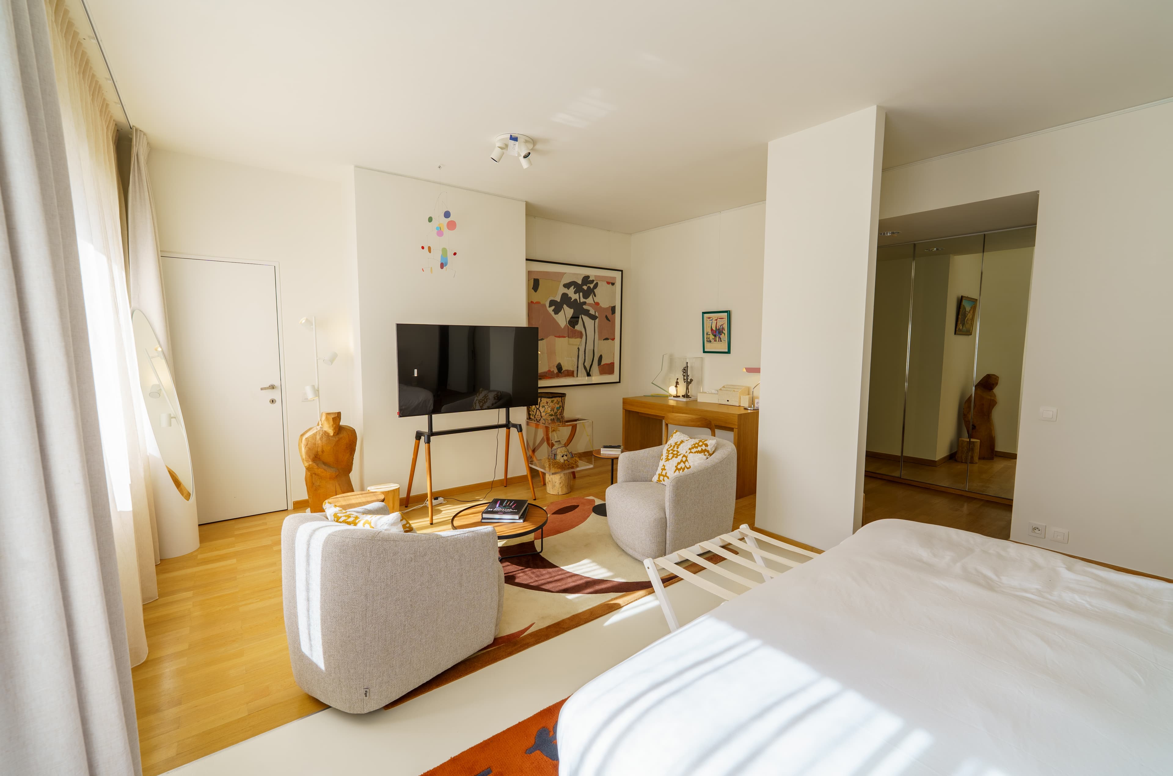 Sitting area with armchairs and a television on a terracotta rug