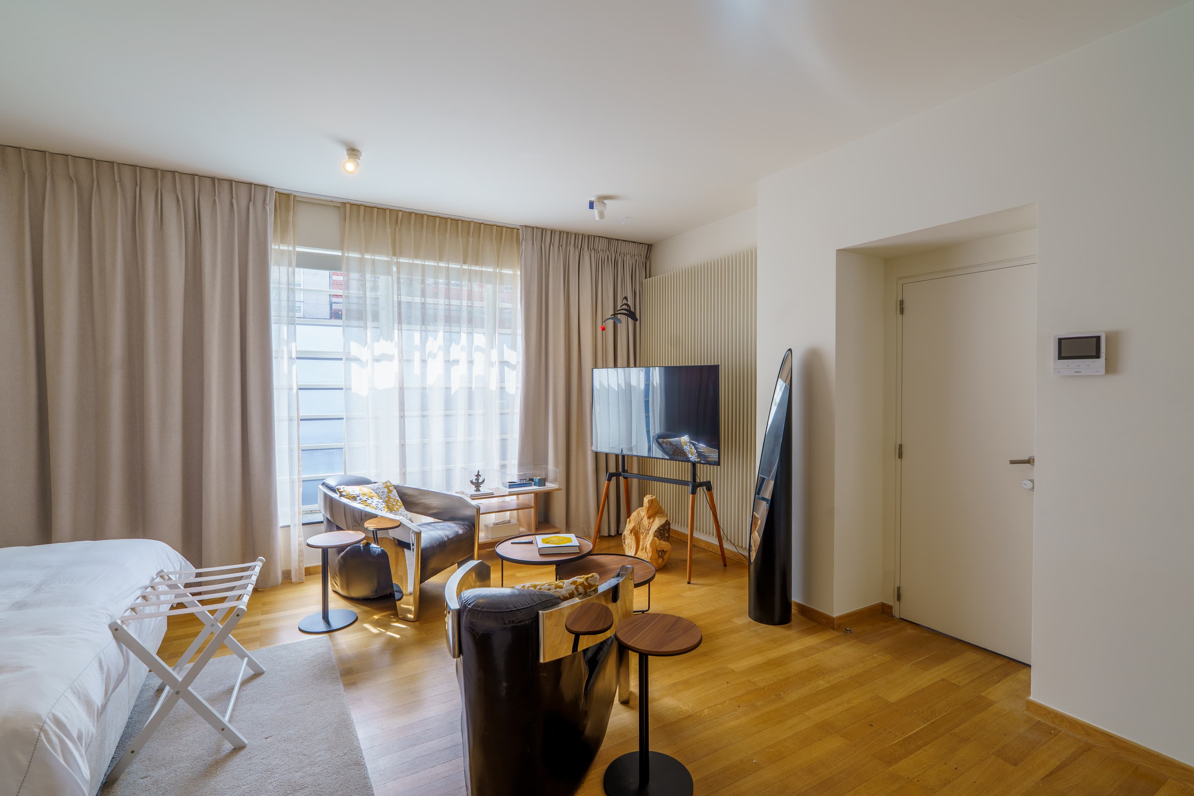 Sitting area with lounge chairs and a television in a ground-floor bedroom