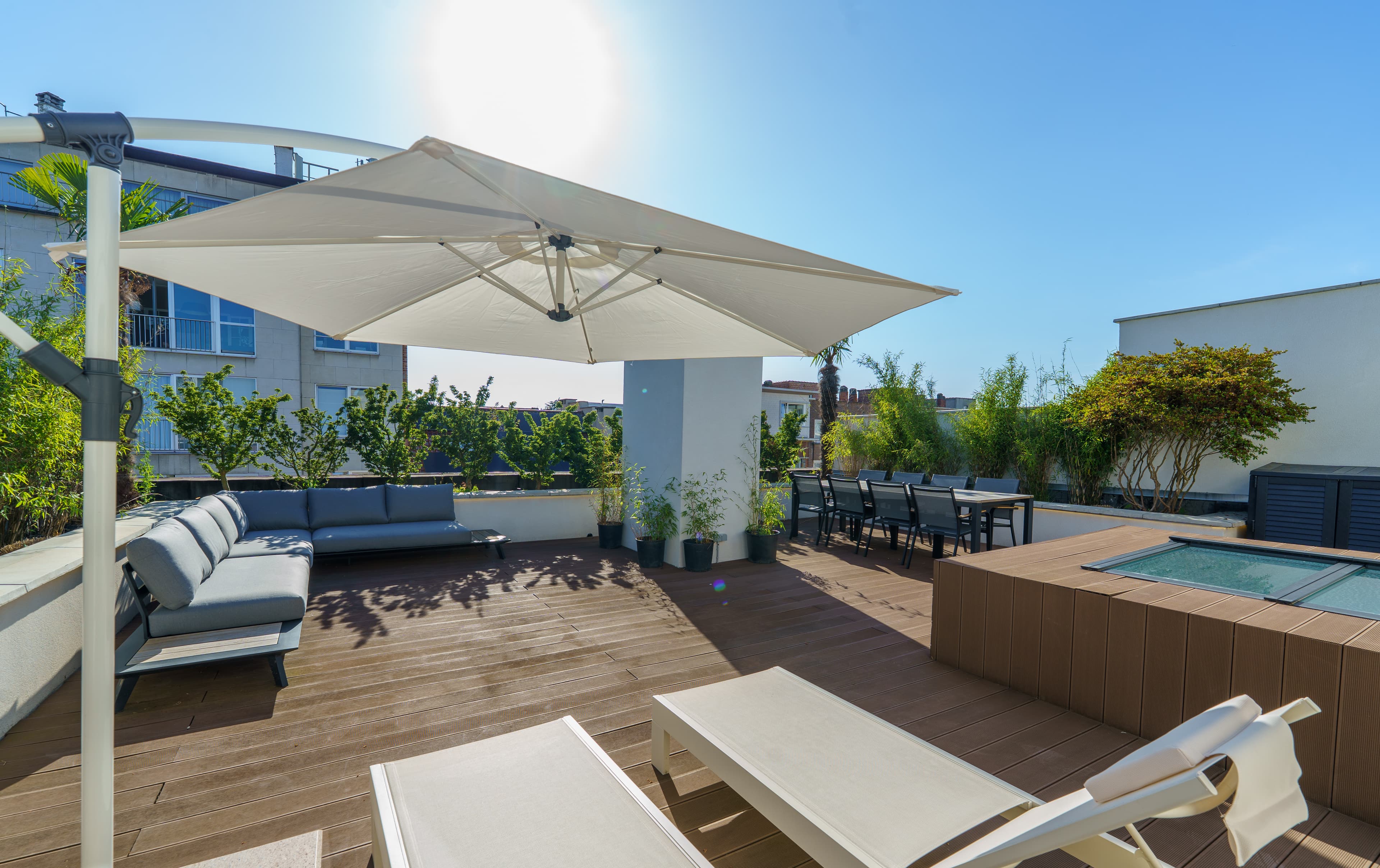 Rooftop terrace with a shaded lounge and a long dining table for ten